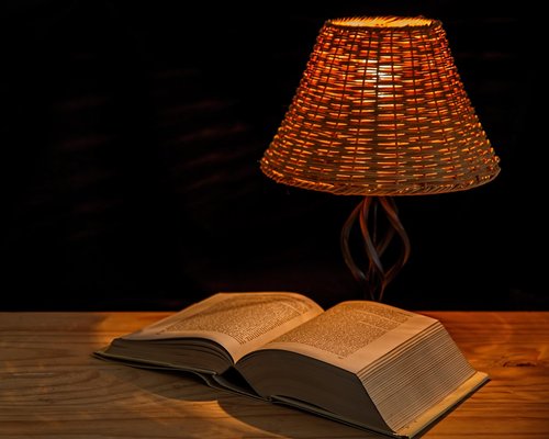 Cozy reading corner with warm desk lamp lighting at night
